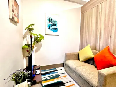 a living room with a couch and a table at Ortigas CBD Greenfield Residences in Manila
