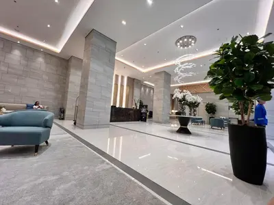a lobby with a blue chair and a plant at Ortigas CBD Greenfield Residences in Manila