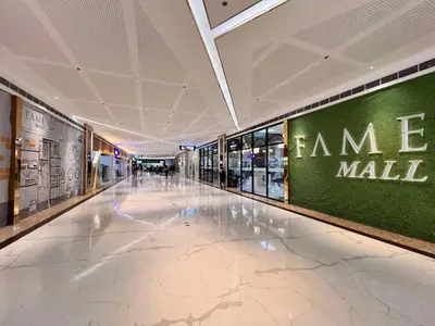 an empty hallway in a mall with a green wall at Ortigas CBD Greenfield Residences in Manila