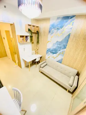 a living room with a couch and a table at MOA SHORE - Exxy SUITES in Manila