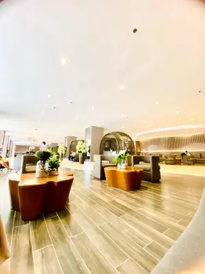 a lobby with couches and plants in a building at MOA SHORE - Exxy SUITES in Manila