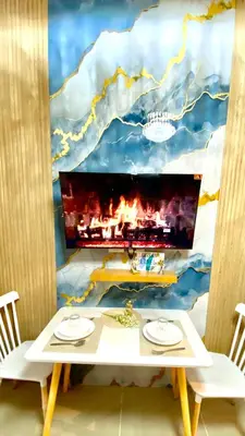 a dining room with a table and a tv on a wall at MOA SHORE - Exxy SUITES in Manila