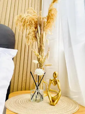 a table with a gold statue and flowers on it at MOA SHORE - Exxy SUITES in Manila