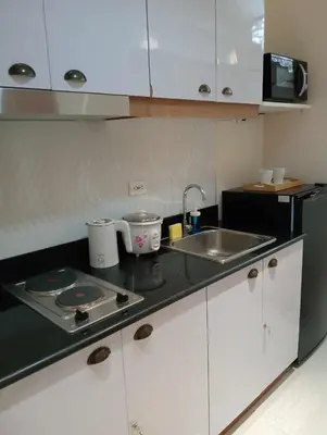 a kitchen with a sink and a counter top at Homefort at Lush Residences Makati Unit 1137 in Manila