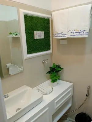 a bathroom with a white sink and a mirror at Homefort at Lush Residences Makati Unit 1137 in Manila