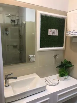 a bathroom with a sink and a glass shower at Homefort at Lush Residences Makati Unit 1137 in Manila