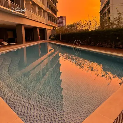 a swimming pool with a reflection of a building at Homefort at Lush Residences Makati Unit 1137 in Manila