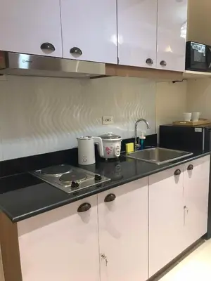 a kitchen with white cabinets and a sink at Homefort at Lush Residences Makati Unit 1137 in Manila