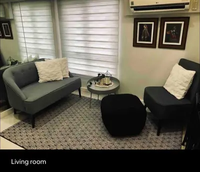 a living room with a couch and a chair at Fort Victoria Condominium Tower C in Manila