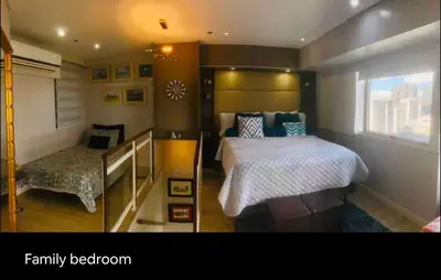 a bedroom with a large bed and a window at Fort Victoria Condominium Tower C in Manila