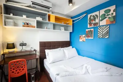 a small bedroom with a bed and a desk at Homey and Cozey Poblacion Makati S03 in Manila