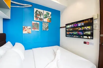 a room with a white couch and a blue wall at Homey and Cozey Poblacion Makati S03 in Manila