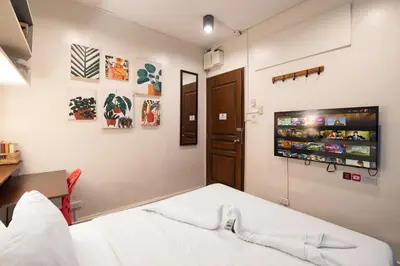a bedroom with a bed and a tv on the wall at Homey and Cozey Poblacion Makati S05 in Manila