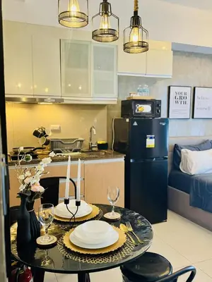 a kitchen with a table with plates and wine glasses at Luxurious Viceroy Residence Walk to Venice Grand Canal in Manila