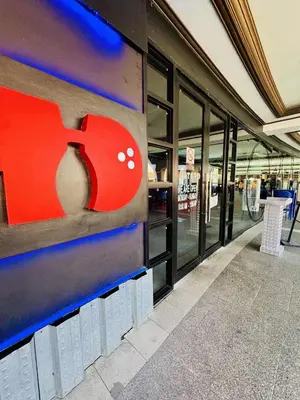 a store with a red apple sign on the side of a building at Luxurious Viceroy Residence Walk to Venice Grand Canal in Manila
