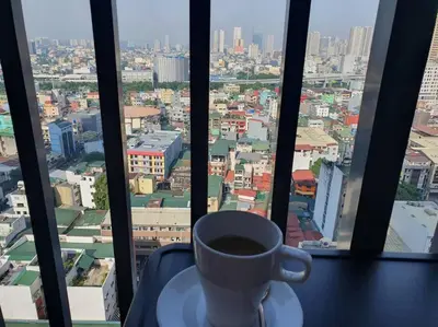 a cup of coffee sitting on a table in front of a window at Red Residence Makati-Cozy Condo Unit with Balcony in Manila