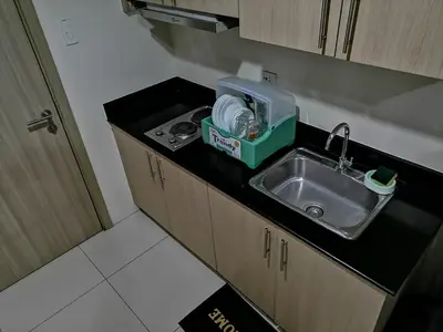 a kitchen counter with a sink in a room at Cozy Urban Apartment in Pasay City in Manila