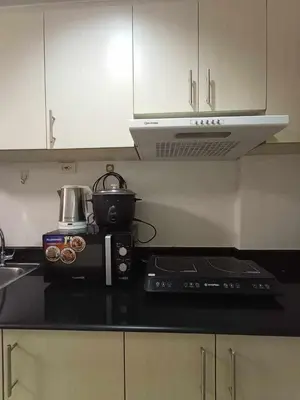 a kitchen with a counter top with a coffee pot on it at Sea Residences Staycation MOA Pasay in Manila