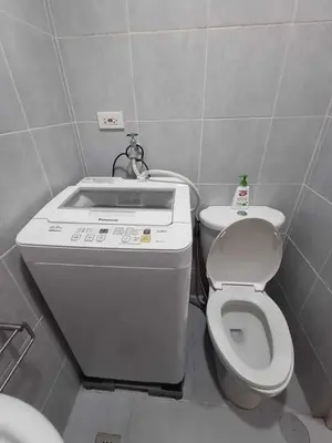a small bathroom with a toilet and a sink at Sea Residences Staycation MOA Pasay in Manila