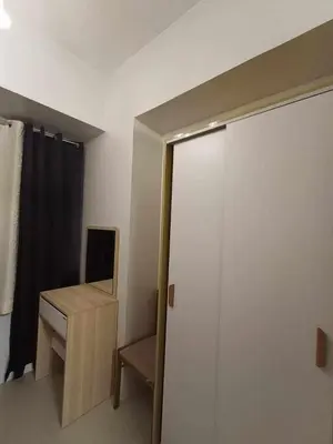 a sliding door in a room with a desk and a mirror at Sea Residences Staycation MOA Pasay in Manila