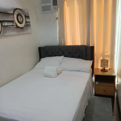 a white bed in a room with a window at Marty's Turf at San Lorenzo in Manila