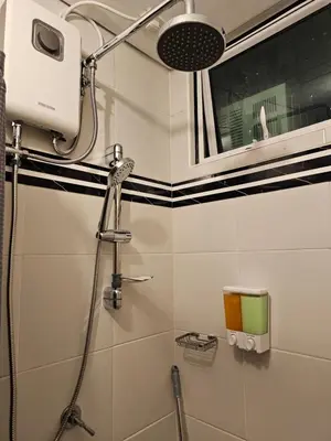a shower in a bathroom with black and white stripes at Marty's Turf at San Lorenzo in Manila