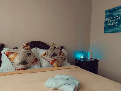 a bed with pillows and a towel on it at One Palm Tree Condominium in Manila