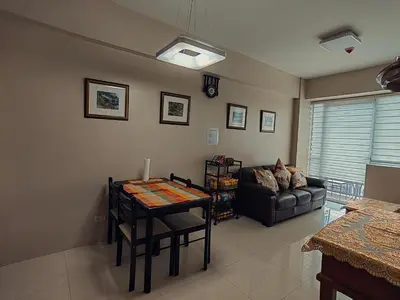 a living room with a table and a couch at One Palm Tree Condominium in Manila