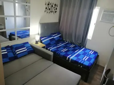 a small room with two beds and a mirror at Homey Staycation in Silang Cavite! Fullerton Suites Puting Kahoy - near CKS, AUP, PNPA, in Puting Kahoy