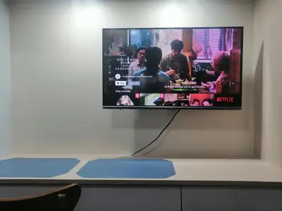 a flat screen tv hanging on a wall at Homey Staycation in Silang Cavite! Fullerton Suites Puting Kahoy - near CKS, AUP, PNPA, in Puting Kahoy