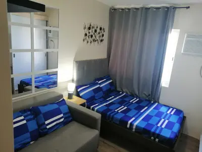 a small bedroom with two beds and a couch at Homey Staycation in Silang Cavite! Fullerton Suites Puting Kahoy - near CKS, AUP, PNPA, in Puting Kahoy