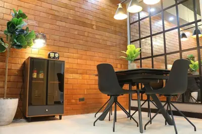 a black table and chairs in front of a brick wall at Kapitolyo Prisma Residential Condo TCPH21 - NYC Vibes Penthouse with KTV Pool and Balcony with City View Panorama 5 Min Drive to BGC St Lukes and Ortigas - Staycations by SMS in Manila
