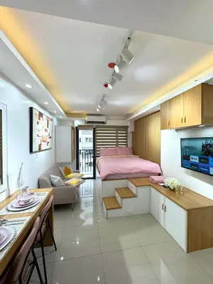 a bedroom with a bed and a living room at Cozy Korean Studio Shore 2 Residences in Manila