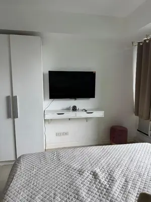 a bedroom with a flat screen tv on a wall at Royale One Five Azure Staycation in Manila