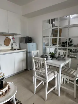 a white kitchen with a white table and chairs at Royale One Five Azure Staycation in Manila