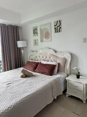 a white bedroom with a white bed with red pillows at Royale One Five Azure Staycation in Manila