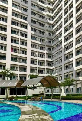 a large apartment building with a large swimming pool at LD Cozy Condo - Grace Residences, Taguig City near BGC in Manila
