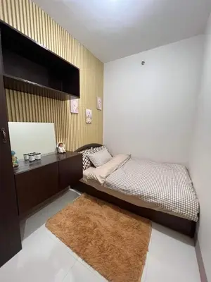 a small bedroom with a bed and a mirror at Trina's Suites in Manila