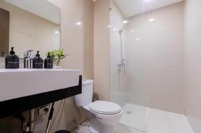 a bathroom with a toilet and a shower and a sink at LUXX BGC Venice in Manila