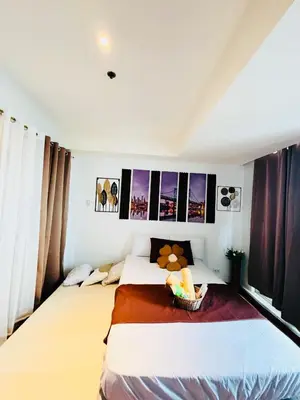 a bedroom with two beds and pictures on the wall at Azure Staycation by Via Sabby in Manila
