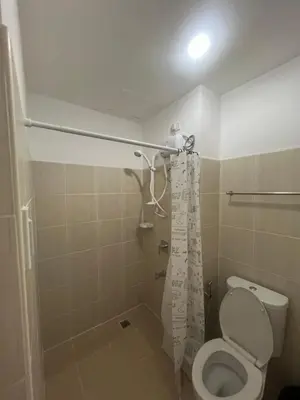 a bathroom with a toilet and a shower at Condo In front of US Embassy Studio Unit with 2 Double Beds in Manila