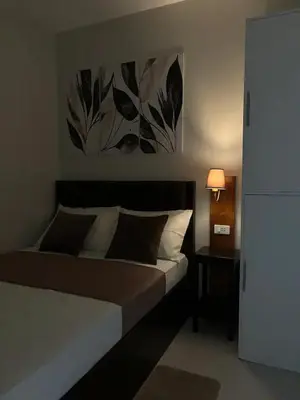 a bedroom with a bed with a painting on the wall at Cozy Condo Stay Near MOA in Manila