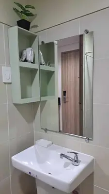a bathroom with a sink and a mirror at Cozy Condo Stay Near MOA in Manila
