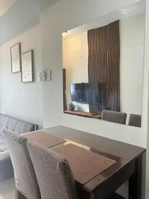 a dining room table with chairs and a mirror at Cozy Condo Stay Near MOA in Manila