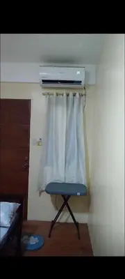 a blue chair in a room with a curtain at Bahay ni Ate Rose in Manila
