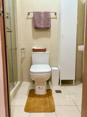 a small bathroom with a toilet and a shower at Design And Den - LK Urban Suites in Manila