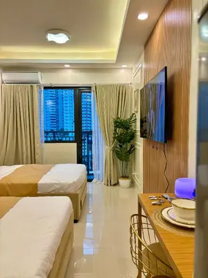 a hotel room with two beds and a table at Design And Den - LK Urban Suites in Manila