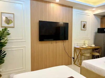 a hotel room with a television on a wall at Design And Den - LK Urban Suites in Manila