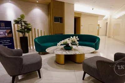 a lobby with a green couch and a table and chairs at Design And Den - LK Urban Suites in Manila