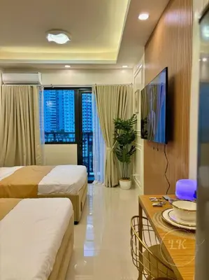 a hotel room with two beds and a table at Design And Den - LK Urban Suites in Manila